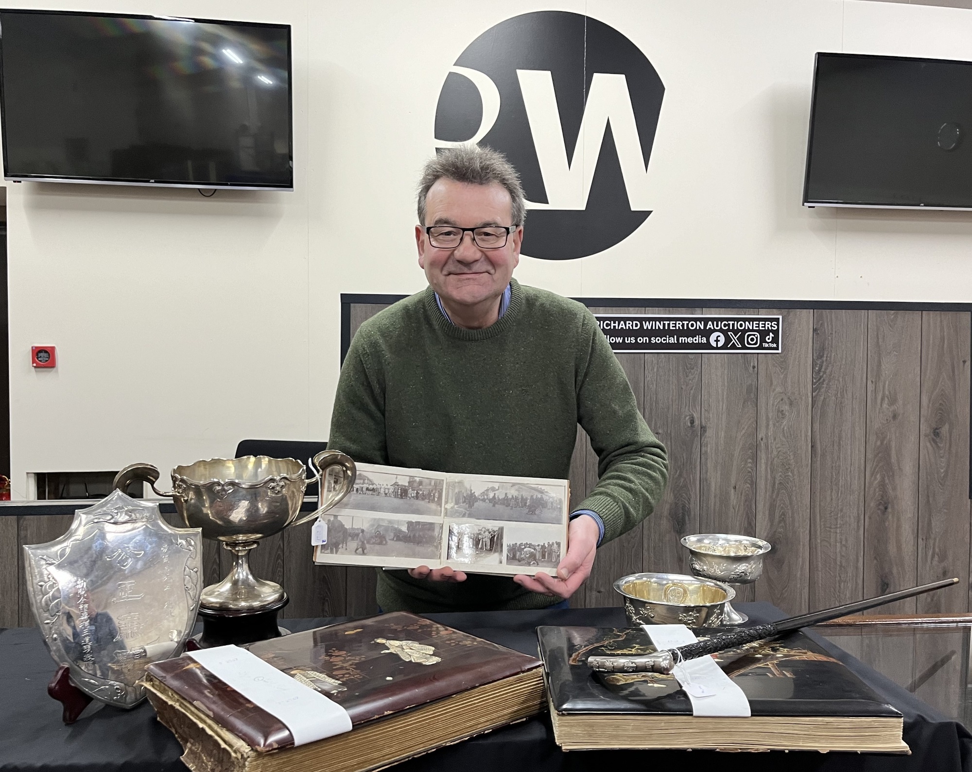 Auctioneer Richard Winterton with the collection of photographs and silver.