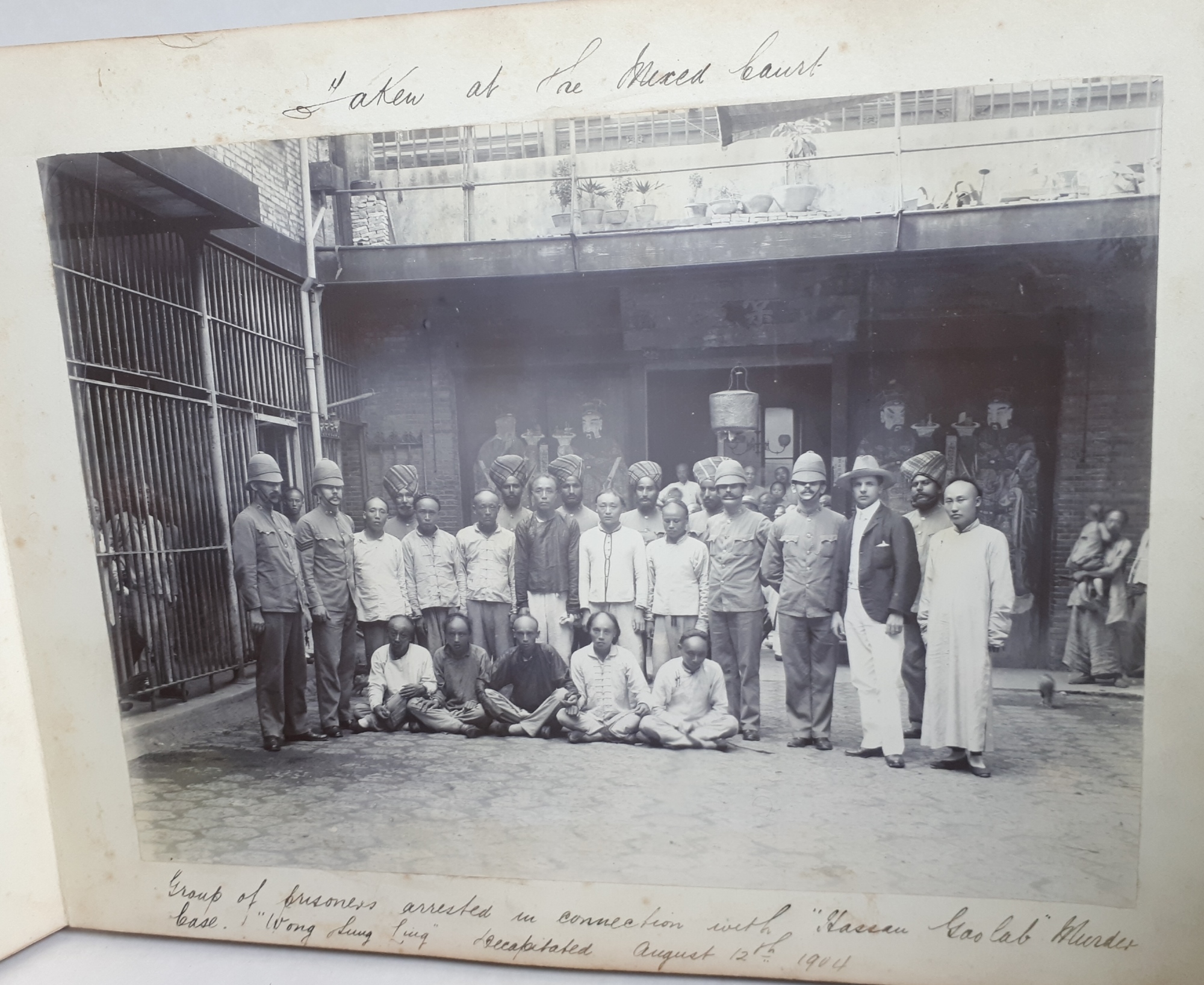 Taken at the mixed court: a group of prisoners arrested in connection with a murder case. The caption says Wong Sung Ling was decapitated on August 12 1904.