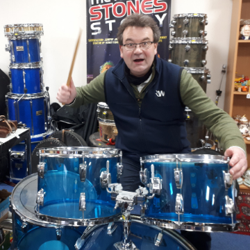 Auctioneer Richard Winterton tries his hand at the drums behind a Ludwig Vistalite kit similar to one used by iconic Led Zeppelin drummer John Bonham.