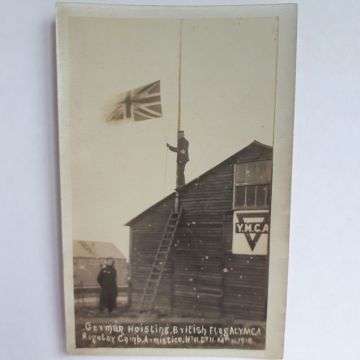 A German prisoner of war hoisting the British flag at the YMCA Rugeley camp on Armistice Day, November 11 1918.