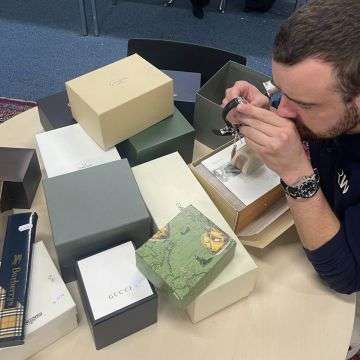 Watch specialist Ben Winterton examining the collection of watches from Sutton Coldfield.