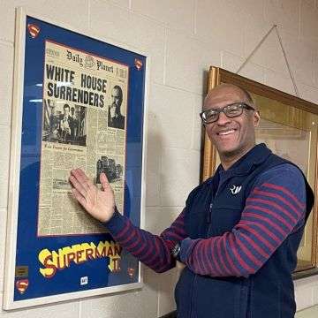 Valuer David Fergus with the Superman II prop replica newspaper.