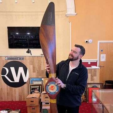 Auctioneer Ben Winterton with the WW1 era aeroplane propeller. The 240cm long wooden airscrew went under the hammer with Richard Winterton Auctioneers for £1,050.