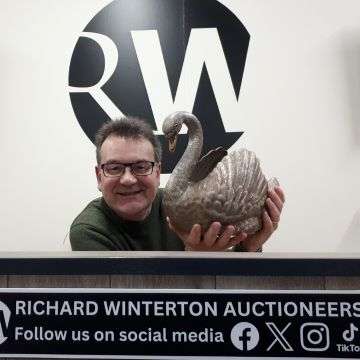 Auctioneer Richard Winterton with the silver swan.