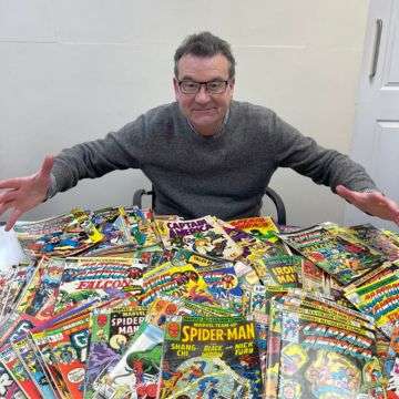 Auctioneer Richard Winterton with a selection of the comics.