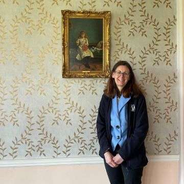 Senior valuer Sarah Williams with an early 20th century oil by George Goodwin Kilburne, ‘A Stitch In Time’.