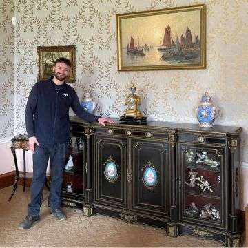 Tom Winterton with a mid-20th century French ebonised and gilt metal and porcelain mounted sideboard.