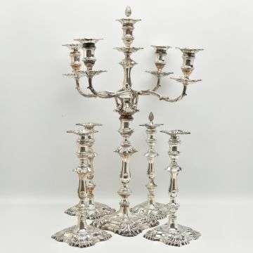 A matching set of four silver candlesticks and candelabrum from a selection of silver in the auction.