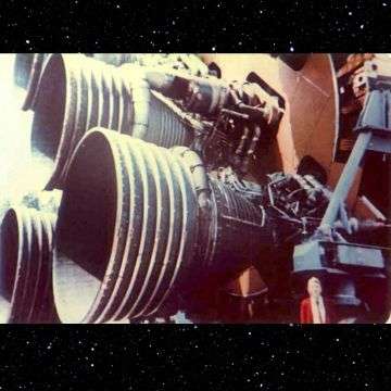 Phill beside the first stage of Apollo Saturn V Moon rocket showing its five giant F-1 rocket engines.